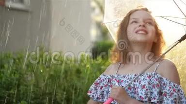 小女孩在雨中打伞。 可爱的孩子有有趣的户外活动。