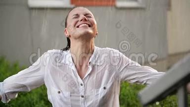 快乐的年轻微笑的女人在雨<strong>天</strong>有乐趣。 开朗的女士有湿发在<strong>夏季</strong>公园。