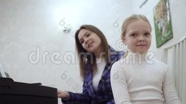 年轻的女老师和小可爱的女孩检查耳朵的音乐。