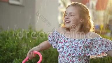 小女孩在雨中打伞。 可爱的孩子在户外玩得很开心。