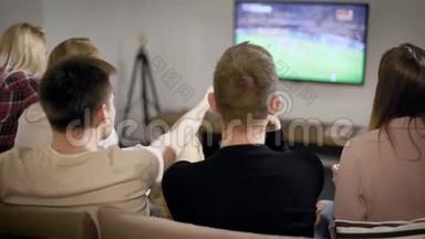 男孩和女孩一起在电视上看足球比赛，朋友一起在室内玩。