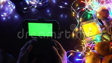 手动使用带有智能手机色度键绿色屏幕的<strong>游戏</strong>垫。 以蜡烛、花环、彩灯组成圣诞<strong>新年</strong>，
