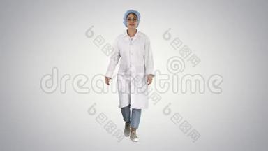 微笑的儿科医生牵着手在口袋里的制服和步行的梯度背景。
