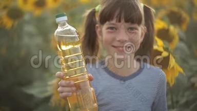 女孩拿着一瓶植物油，站在田野里向日葵。 农业、有机食品和健康食品
