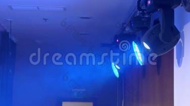 舞台上的照明设备.. 在聚光灯下吸蓝色的烟。 音乐剧，音乐会，表演。
