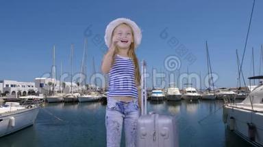 带旅行箱的旅游女孩，游艇背景下的海港等待船