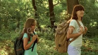 带背包的快乐女孩旅行者穿过森林的灌木丛。 儿童游客在夏季公园旅行