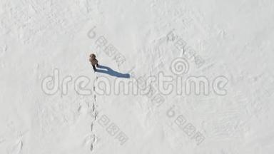 孤独的人在白雪皑皑的北极沙漠中行走。 从上面看。 孤独和克服。