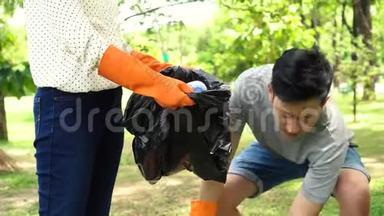一群带手套的<strong>志愿者</strong>把垃圾收集到公园的垃圾袋里