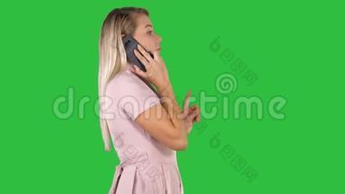 可爱的女人在绿色屏幕<strong>上走来走去</strong>，在电话里聊天，Chroma键。