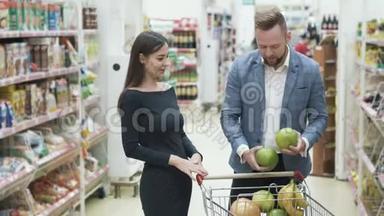 正面视频年轻夫妇，女人在<strong>超市</strong>用<strong>水果</strong>做滑稽的脸