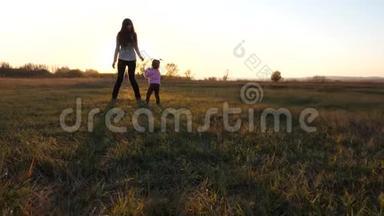 孩子在田里<strong>打球</strong>，妈妈照顾女儿。 日落时分，孩子们把足球的手扔在公园的草地上