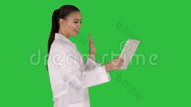 年轻的女医生手里拿着平板电脑，在<strong>绿</strong>色屏<strong>幕</strong>上打<strong>视频</strong>电话，Chroma键。