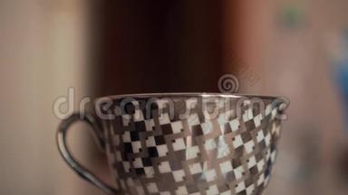 桌子上的灰色杯子。 从水壶里倒开水.. 侧视，从杯子里看到一对夫妇。