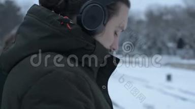 特写镜头：一位留着耳机胡须的长发青年，冬天站在电车站等待