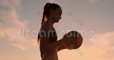 沙滩排球发球-女子发球在沙滩排球比赛. 上面的钉子发球。 年轻人在娱乐