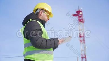 从事数字平板电脑工作的工程师，在电信塔上有卫星天线电信网络。