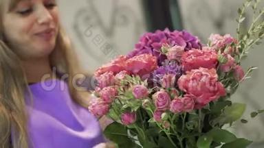 微笑的女孩花店带着一束美丽的花。 可爱的女孩在花店捧着一束花