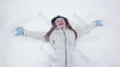 一个年轻的女孩在冬天和雪地里快乐，在冬天的公园里玩耍，不躺在雪地里