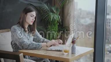 年轻女子在键盘上打字，聊天，写博客。 自由职业者在现代合作中的上网本工作。 成功人士