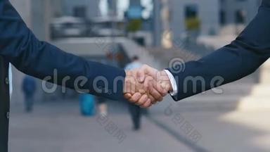 在商务中心后台，与穿着商务服的高级管理人员握手，握手