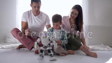 现代童年，可爱的孩子和父母玩智能机器人<strong>遥控手机</strong>坐在地板上