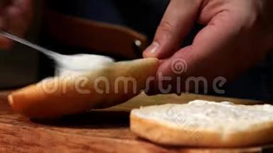 厨师把酱汁放在汉堡的面包上。 库存录像。 厨师为汉堡准备酱汁，然后穿<strong>上新</strong>鲜的