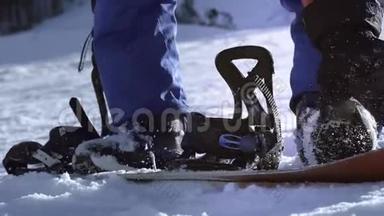 职业骑手把滑雪板放在脚上。扣件。准备滑雪或滑雪板。喜欢冬季运动