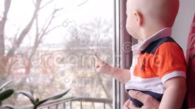 靠近一个小男孩，他和他的<strong>老爷爷</strong>在窗前的一棵树的背景下玩耍