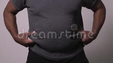 非裔美国人男式提升衬衫，展示大腹便便和爱情手柄