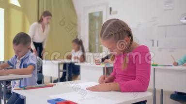 小女生坐在课桌后面，以同学为背景，在光线教室里上课。