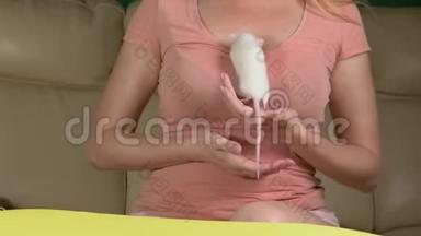 训练一只白老鼠。 美丽的年轻女子手里拿着一只老鼠，老鼠爬上了女人的肩膀