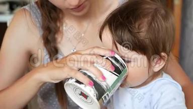 妈妈喂宝宝<strong>看手机</strong>.. 一位抱着一个小孩子的年轻母亲拿着一部智能<strong>手机</strong>，<strong>看</strong>着她