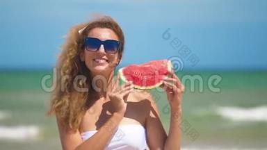微笑的女人在海滩上<strong>吃西瓜</strong>。 女人<strong>吃</strong>美味的夏天水果。 暑假快乐。
