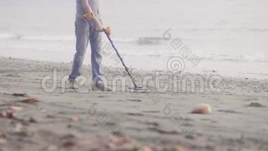 人们在沙滩上寻找<strong>贵重物品</strong>，在日出时使用金属探测器，双腿特写。