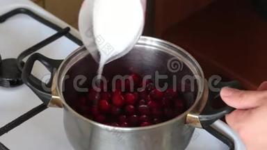 一个人把量杯中的糖加到平底锅中冷冻的蔓越莓中。 为棉花糖准备土豆泥。