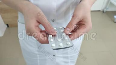 穿着白色制服的医生手里拿着一颗药丸。 <strong>药学</strong>，人与健康理念.. 治疗药物处方