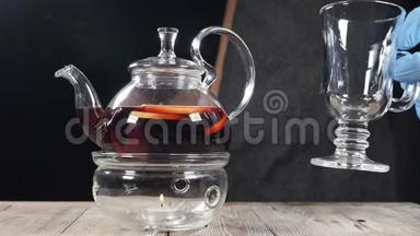 厨师用透明茶壶放一个空<strong>玻璃杯</strong>，里面有新鲜的草药和<strong>水果</strong>饮料。 餐厅里舒适的气氛