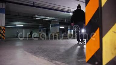 滑板训练。 一个年轻人在停车场里玩滑板，停下来，手里拿着滑板走了