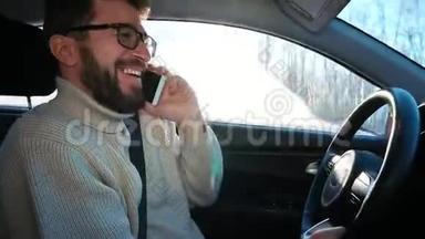 冬天，一个人在城市之间的公路上开车。 他在说智能手机，笑着。 他吓坏了，