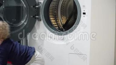 一岁男孩在家里看<strong>洗衣机</strong>。家用电器问题。小男孩关上<strong>洗衣机</strong>