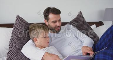 <strong>父亲和儿子</strong>躺<strong>在</strong>床上，<strong>在家里</strong>的卧室里读一本故事书