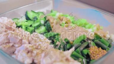 特写，慢动作，沙拉在一个玻璃沙拉碗鸡肉和绿色植物，调味芝麻酱和<strong>法国菜</strong>