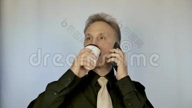 一个中等身材的男人喝咖啡，打电话。 他领导商务谈判