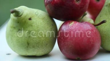 成熟的<strong>水果</strong>：绿梨、红苹果和<strong>黄</strong>樱<strong>桃</strong>李躺在一张白色的乡村桌子上，背景是绿色的花园