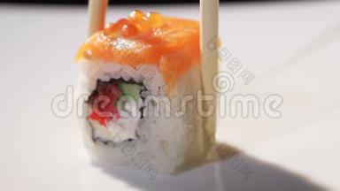 <strong>筷子</strong>在日本餐馆吃寿司。 特写镜头。 带有寿司的时尚白色<strong>盘子</strong>