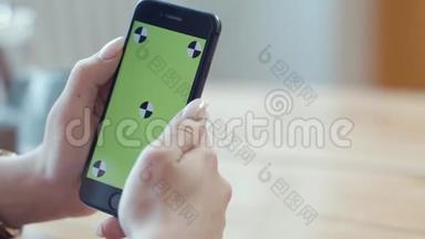 年轻的女人有漂亮的指甲，手里拿着iPhone，在彩色钥匙绿色屏幕上打字。 库存数据