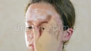 十几岁的女孩把<strong>保湿面膜</strong>贴在脸上。