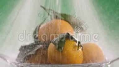 在橘子上注入强劲的水流，在视频的末尾，水停止了，绿色的背景
