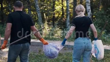 两名志愿者在清理森林后拿出垃圾和回收塑料瓶